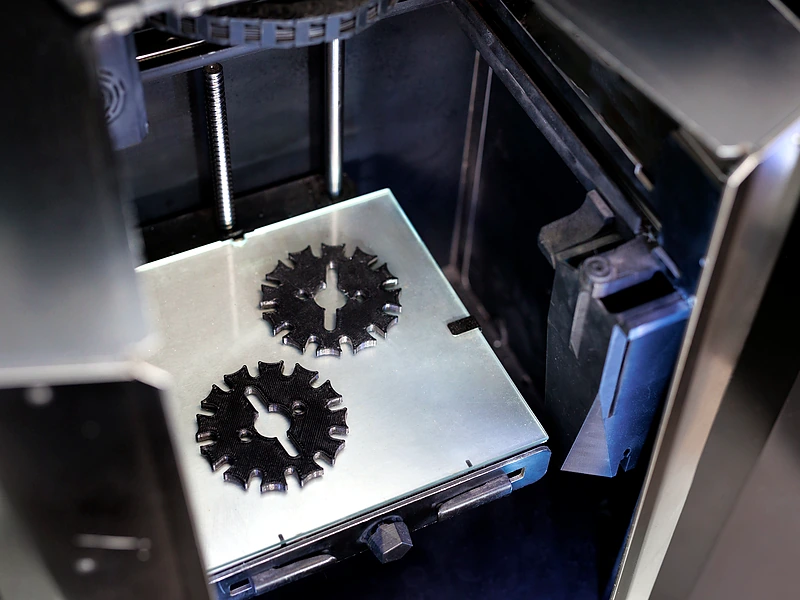 Metal 3D printed gears on build plate after additive manufacturing